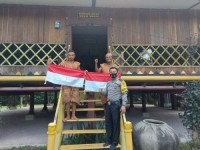 Tumbuhkan Sikap Patriotisme Bhabinkamtibmas Serahkan Bendera Merah Putih Kepada Masyarakaf Adat Saka